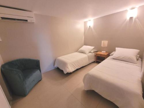une chambre d'hôtel avec deux lits et une chaise dans l'établissement COSY COTTAGE Private POOL, à La Turbie