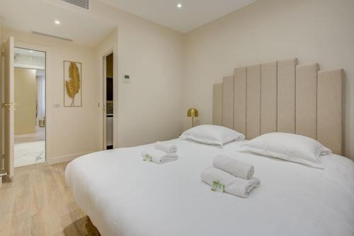 - une chambre blanche avec un grand lit blanc et des oreillers blancs dans l'établissement Peaceful Getaway near Marais - with AC, à Paris