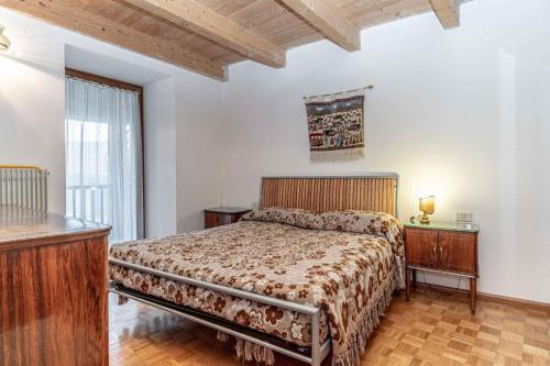 a bedroom with a large bed and a window at Casa Rita, Altopiano di Piné Ospitar in Pergine Valsugana