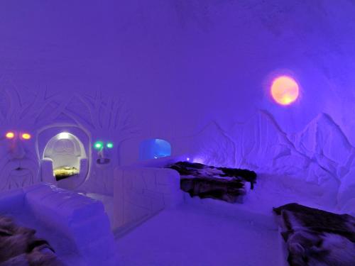an ice hotel room with purple lights and a bed at Hunderfossen Snow Hotel in Hafjell