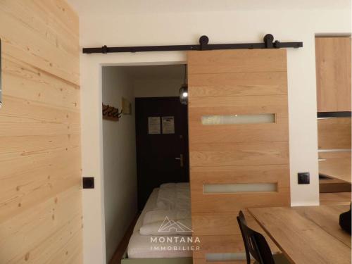 Cette chambre comprend un lit et un mur en bois. dans l'établissement Studio rénové pour 4 au Grand-Bornand, balcon, casier à ski - FR-1-458-194, au Grand-Bornand