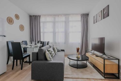 a living room with a couch and a dining room at Modern Apartment - 2BR-6P- Levallois-Perret in Levallois-Perret