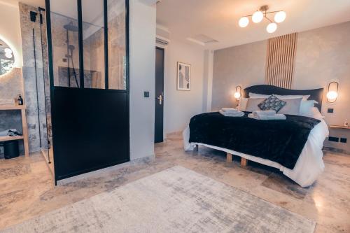 a bedroom with a bed and a large glass door at Les Suites de l'Étang in Cucuron