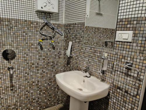 a tiled bathroom with a sink and a shower at The Mountain Shades Resort in Madikeri