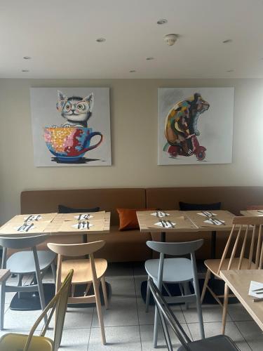 a restaurant with tables and chairs and paintings on the wall at Campanile Paris 14 - Maine Montparnasse in Paris