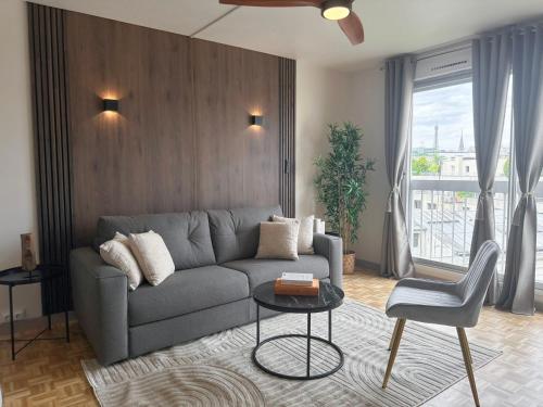 a living room with a couch and a table at Brand-new studio with Eiffel Tower view in Paris
