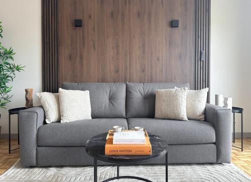 a living room with a grey couch and a table at Brand-new studio with Eiffel Tower view in Paris