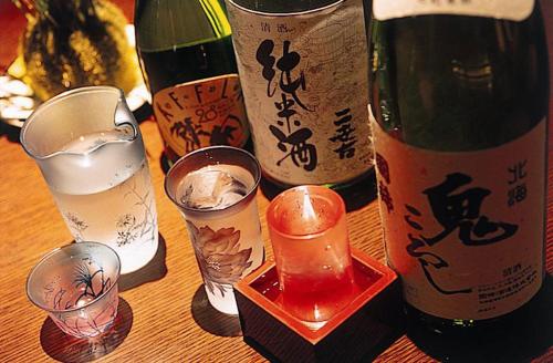 a group of wine bottles and glasses on a table at Hotel Kanronomori in Niseko