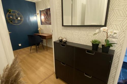 Cette chambre comprend une commode avec un miroir et une table. dans l'établissement T2 refait à neuf Lille ! Parc Monceau, à Lille