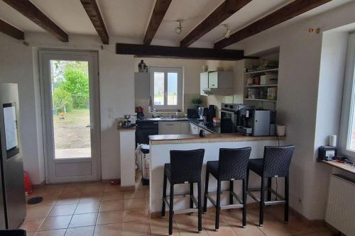 - une cuisine avec un bar avec des chaises et un comptoir dans l'établissement Grande Maison de Campagne, à Saint-Vincent