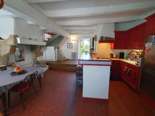 une cuisine avec des placards rouges, une table et un comptoir dans l'établissement Sur le balcon des marais salants, à Guérande