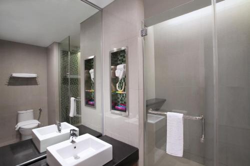 ein Bad mit einem Waschbecken, einem WC und einer Dusche in der Unterkunft Ibis Styles Jakarta Sunter in Jakarta