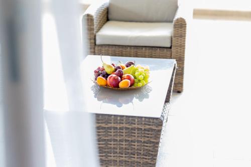 a bowl of fruit on a table next to a couch at Apartmani Milos - Meljine in Herceg-Novi