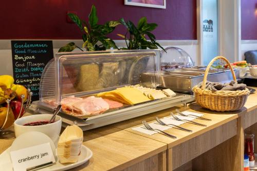 a buffet with meat and other food on a counter at Hotel Oepkes in West-Terschelling