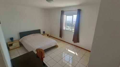 une petite chambre avec un lit et une fenêtre dans l'établissement Kaze Bretagne - Évasion à Saint-Denis - Charmante Maison T3 avec Terrasse, Jardin et Vue Imprenable - Proche Aéroport, à Saint-Denis