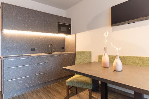 a kitchen with a table and two vases on it at Hotel Martellerhof in Martello