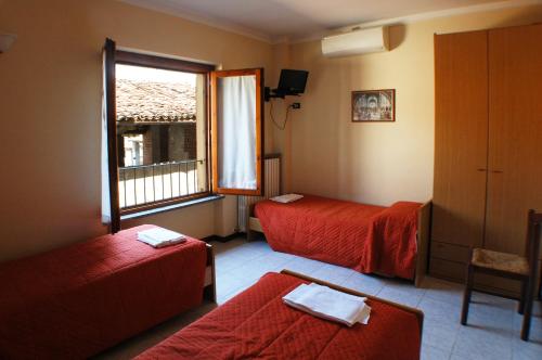 a hotel room with two beds and a window at Locanda Del Sole in Mozzanica
