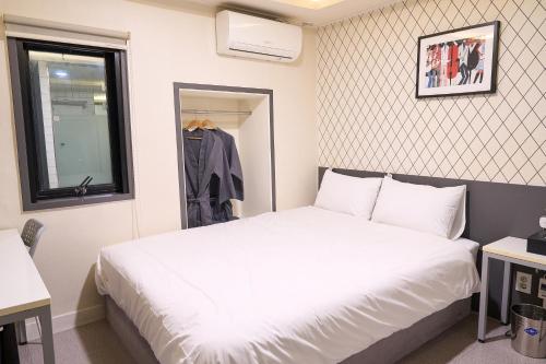 a bedroom with a white bed and a window at Hyuzen Hotel - 휴젠 in Seoul