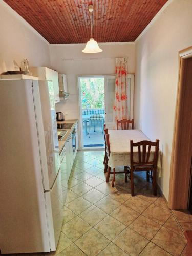 a kitchen and dining room with a table and a refrigerator at Morska in Orebić