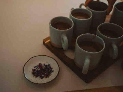 a group of coffee cups on a tray with a plate at Herrings House, an iconic designer nature retreat in Willunga