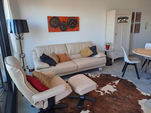 een woonkamer met een bank, stoelen en een tafel bij EnJOY Zee en uitzicht op Hinterland Westende in Middelkerke