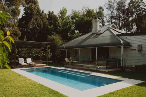 a swimming pool in a yard next to a house at Herrings House, an iconic designer nature retreat in Willunga