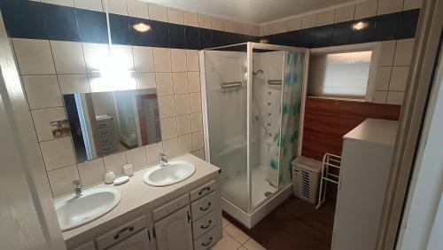 une salle de bain avec deux lavabos et une douche dans l'établissement Kaze Bretagne - Évasion à Saint-Denis - Charmante Maison T3 avec Terrasse, Jardin et Vue Imprenable - Proche Aéroport, à Saint-Denis