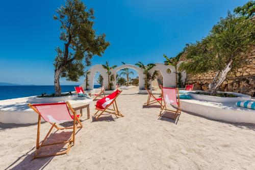 a group of chairs and a table on the beach at Stone Beach Residence - Adults Only Resort in Qeparo