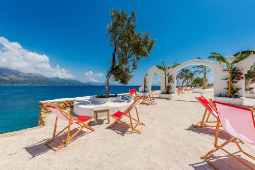 a group of chairs and a table on a beach at Stone Beach Residence - Adults Only Resort in Qeparo