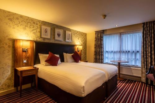 a hotel room with a large bed and a window at Gloucester Robinswood Hotel, BW Signature Collection in Gloucester