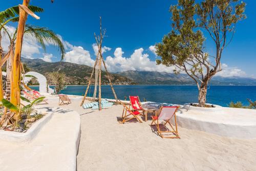 a group of chairs on a beach with the water at Stone Beach Residence - Adults Only Resort in Qeparo