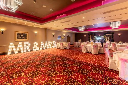 a banquet hall with white tables and a sign that says mr and mrs at Gloucester Robinswood Hotel, BW Signature Collection in Gloucester