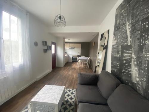 un salon avec un canapé et une table dans l'établissement La maison deThéo, à Les Pavillons-sous-Bois