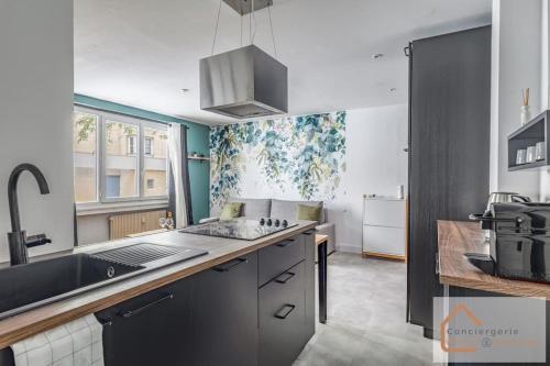 une cuisine avec un évier et un plan de travail dans l'établissement Évasion Urbaine - Confort Moderne pour 4 Voyageurs, à Lyon