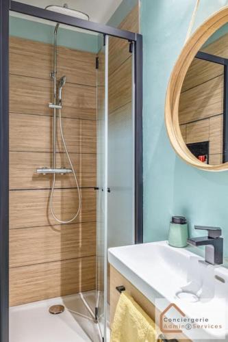 une salle de bain avec douche et lavabo dans l'établissement Évasion Urbaine - Confort Moderne pour 4 Voyageurs, à Lyon