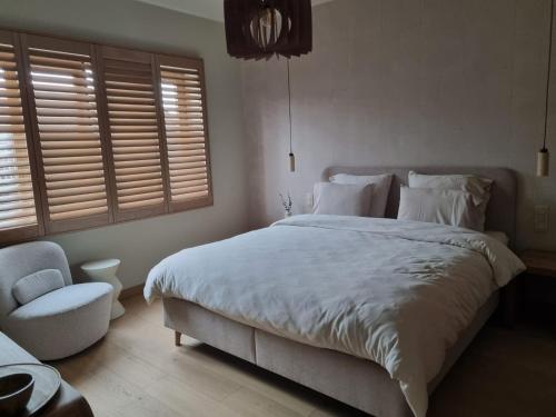 a bedroom with a large bed and a chair at Nova Nocte in Tongeren