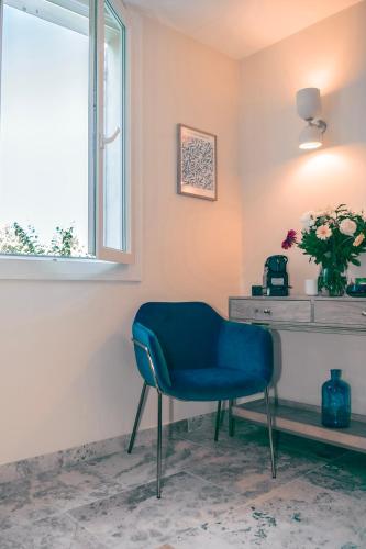 a blue chair sitting in a room with a window at Les Suites de l'Étang in Cucuron