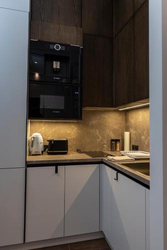 une cuisine avec des armoires blanches et des appareils noirs dans l'établissement Apartments in the heart of Cannes, à Cannes