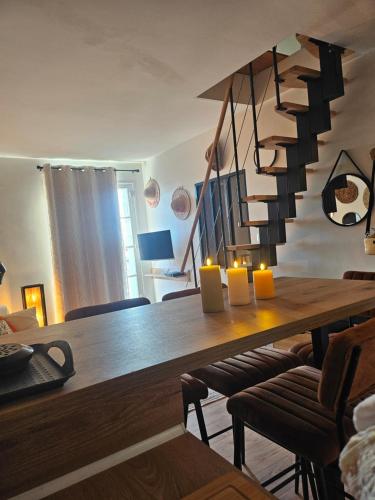 une salle à manger avec une table en bois et un escalier dans l'établissement appartement sérénité, à Grimaud