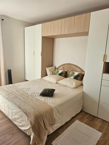 une chambre avec un grand lit avec des draps et des oreillers blancs dans l'établissement appartement sérénité, à Grimaud