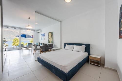 a hotel room with a bed and a dining room at Stone Beach Residence - Adults Only Resort in Qeparo