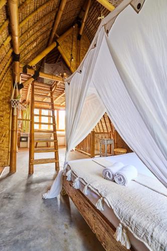 a bedroom with a bed with a mosquito net at 360 Surf Camp in Kuta Lombok