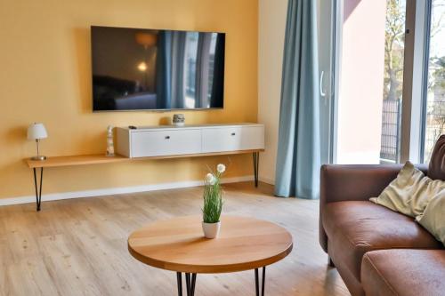a living room with a couch and a tv on the wall at Villa Am Stadthafen - 200m zur Ostsee in Sassnitz