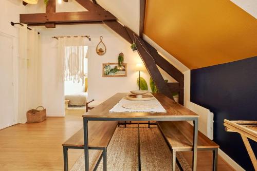 une salle à manger avec une table et un mur bleu dans l'établissement Bourgon flat, à Paris
