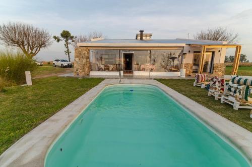 a swimming pool in front of a house at Alma Drabble in José Enrique Rodó