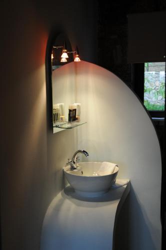 a bathroom with a white sink and a mirror at Naiades Village in Polydrossos