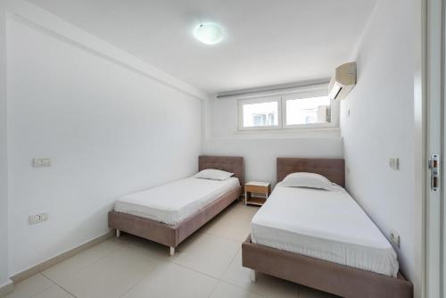 a room with two beds and a window at Stone Beach Residence - Adults Only Resort in Qeparo