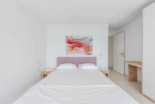 a white bedroom with a large white bed at Stone Beach Residence - Adults Only Resort in Qeparo