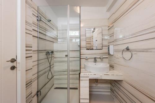 a bathroom with a sink and a shower at Stone Beach Residence - Adults Only Resort in Qeparo