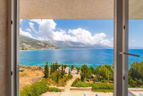 a window with a view of the ocean at Stone Beach Residence - Adults Only Resort in Qeparo